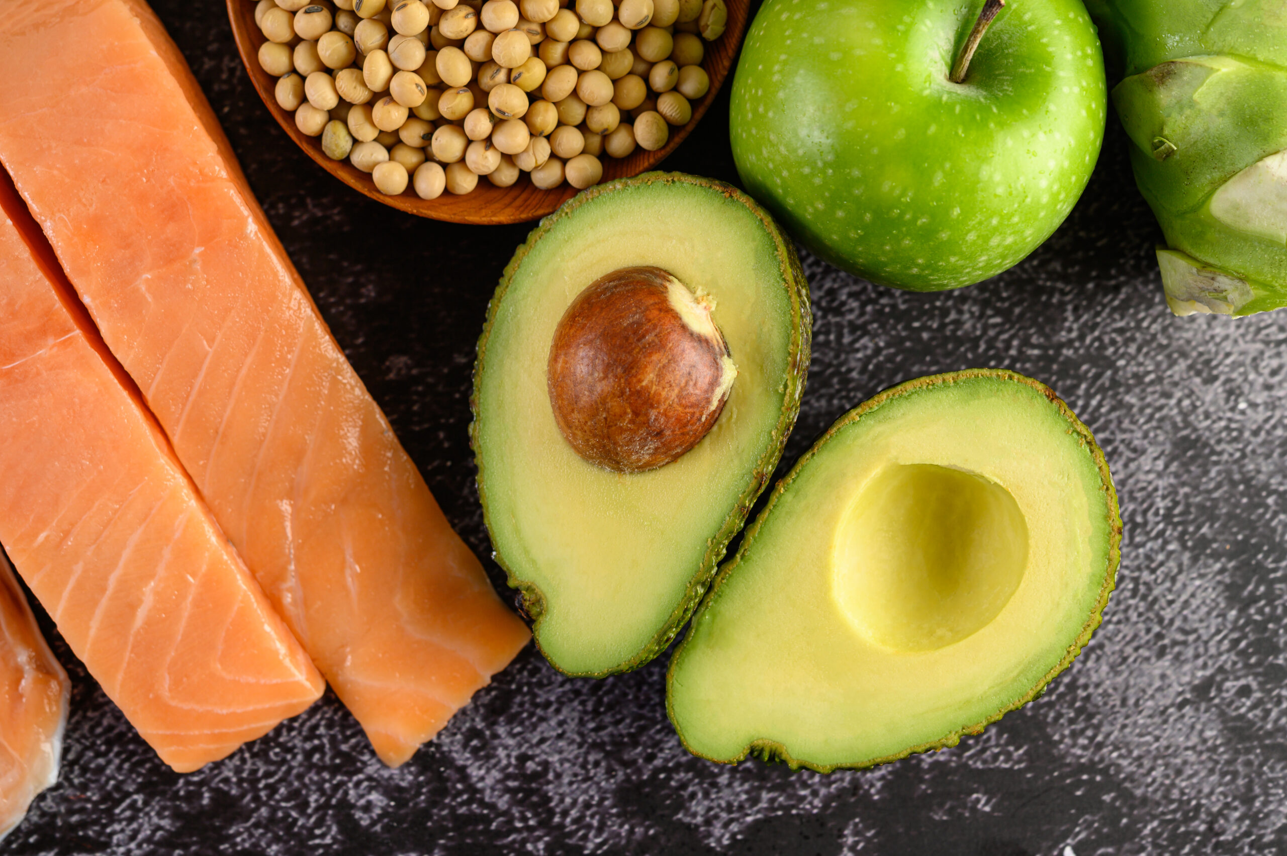 Legumes, fruit, and salmon placed on a black cement floor. Legumes, fruit, and salmon placed on a black cement floor.
